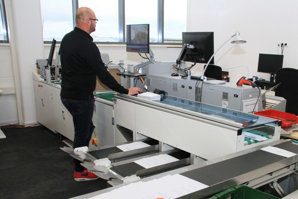 Homme utilisant une machine de scanning pour digitaliser du courrier